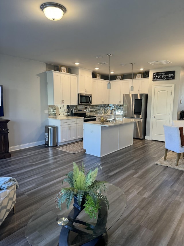 kitchen with stainless steel appliances, hanging light fixtures, dark wood-type flooring, and white cabinets