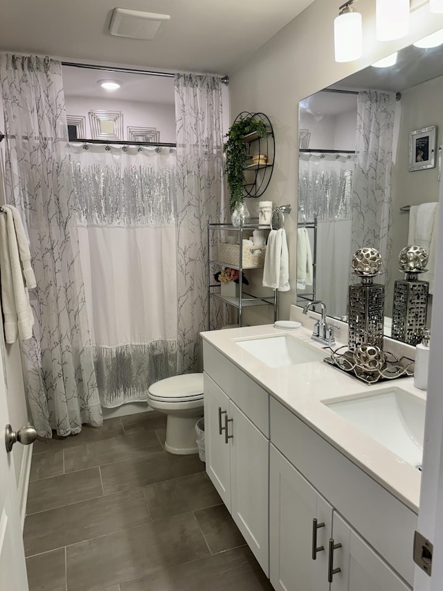 full bathroom with vanity, shower / tub combo, and toilet