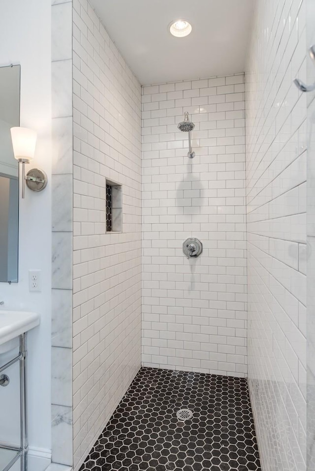 bathroom with vanity and a tile shower