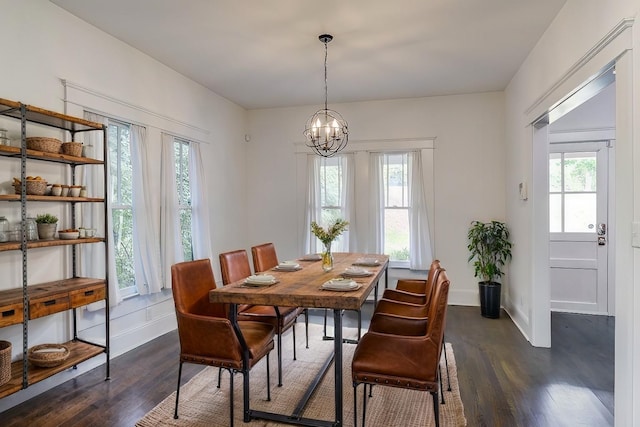 dining area featuring plenty of natural light, an inviting chandelier, and dark hardwood / wood-style flooring