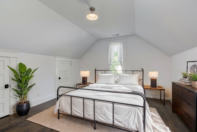 bedroom featuring lofted ceiling and dark hardwood / wood-style floors