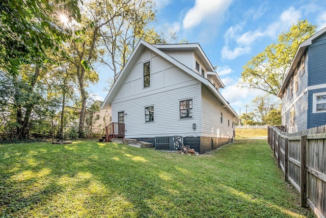 back of property with a lawn and central air condition unit