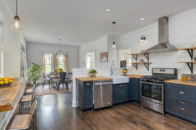 kitchen featuring sink, butcher block countertops, appliances with stainless steel finishes, dark hardwood / wood-style floors, and island exhaust hood