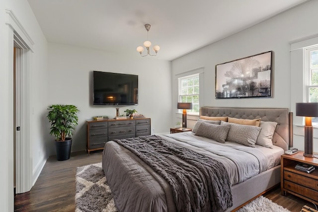 bedroom featuring an inviting chandelier and dark hardwood / wood-style floors