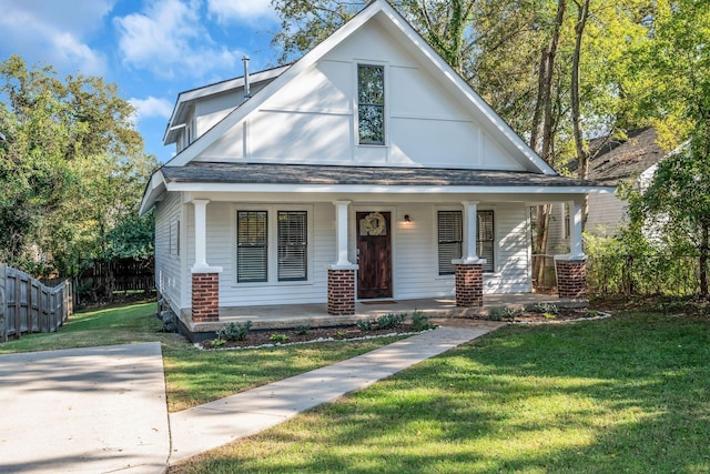 view of front of home with covered porch and a front lawn