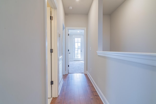 corridor with hardwood / wood-style flooring