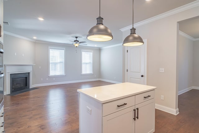 kitchen featuring decorative light fixtures, ornamental molding, dark hardwood / wood-style floors, a kitchen island, and white cabinets