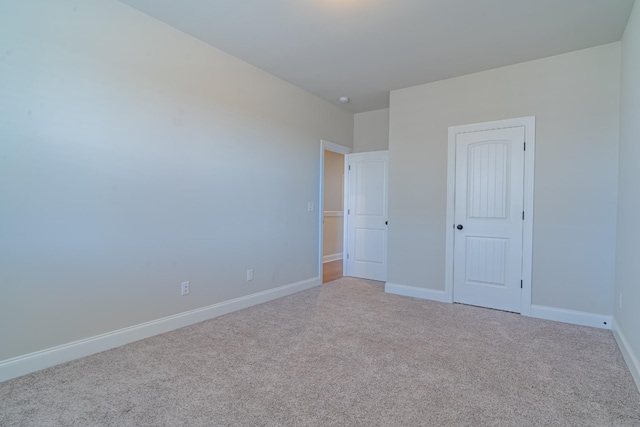 unfurnished bedroom featuring light carpet and a closet