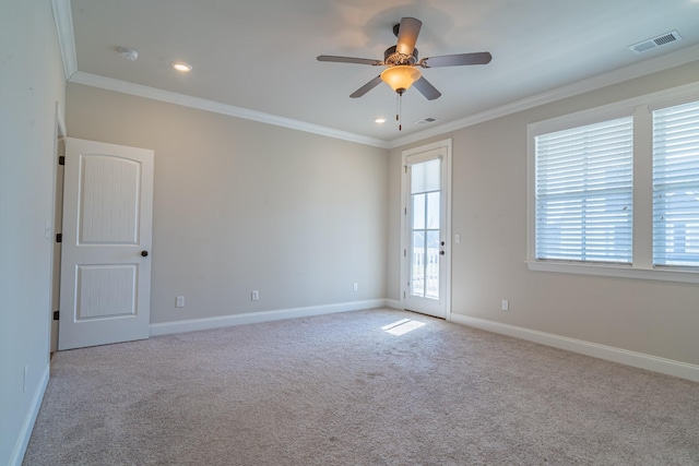 spare room featuring crown molding, light carpet, and ceiling fan