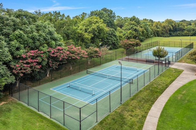 view of tennis court featuring a yard