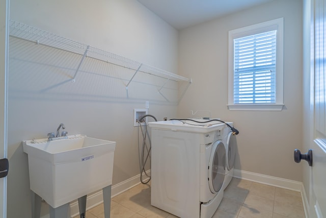 washroom with light tile patterned floors, sink, and independent washer and dryer