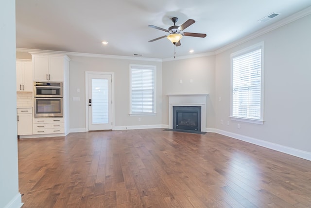 unfurnished living room with ceiling fan, ornamental molding, and dark hardwood / wood-style flooring