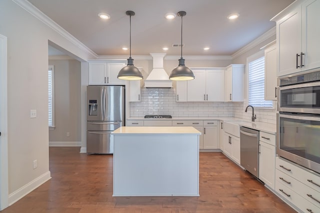 kitchen featuring stainless steel appliances, custom exhaust hood, pendant lighting, and white cabinetry