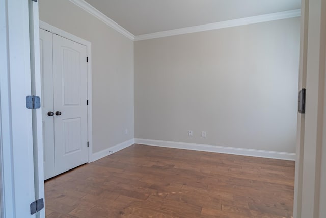 empty room with hardwood / wood-style flooring and ornamental molding