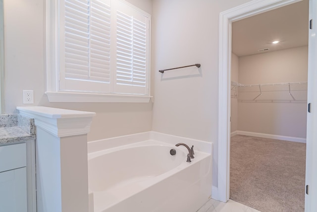 bathroom with vanity and a bath