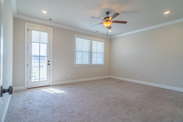 empty room with crown molding, plenty of natural light, and light colored carpet