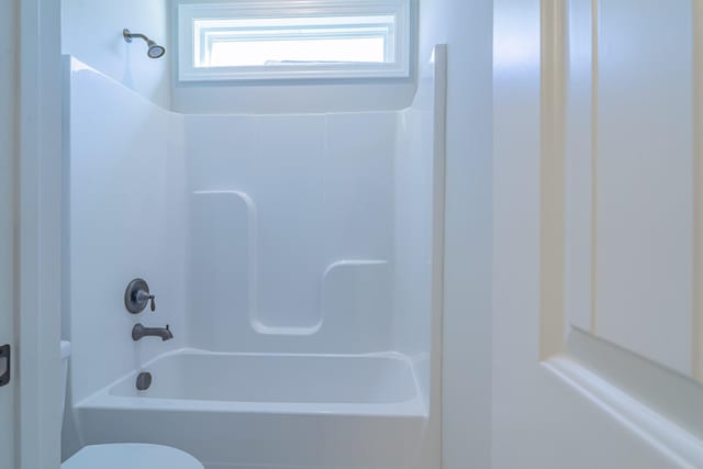 bathroom with shower / washtub combination and toilet