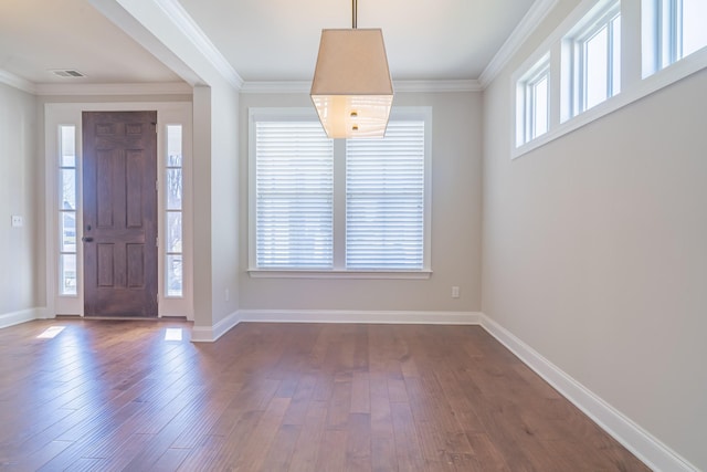 foyer with ornamental molding and dark hardwood / wood-style floors