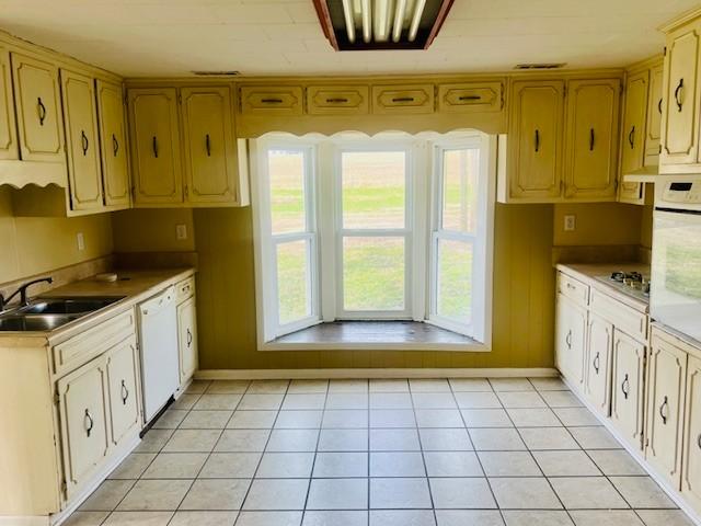 kitchen with sink, white appliances, and light tile patterned floors