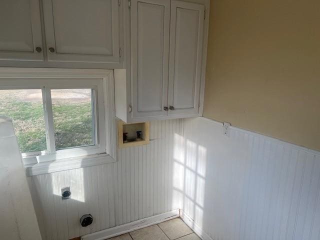 washroom featuring cabinets, washer hookup, light tile patterned floors, and electric dryer hookup