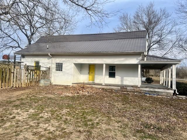 rear view of property featuring covered porch