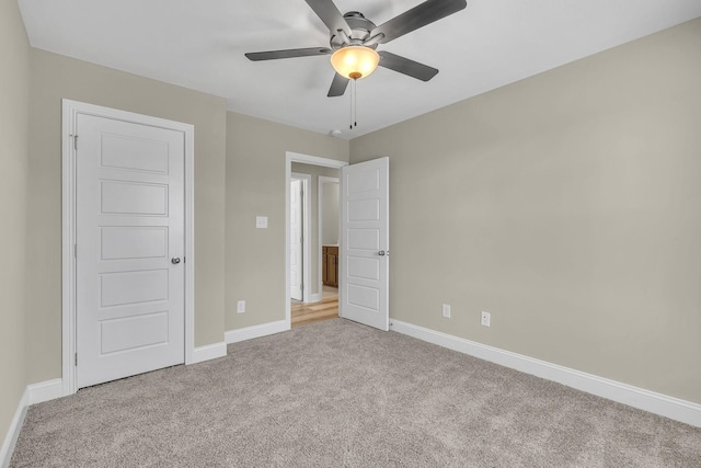 unfurnished bedroom featuring light colored carpet and ceiling fan