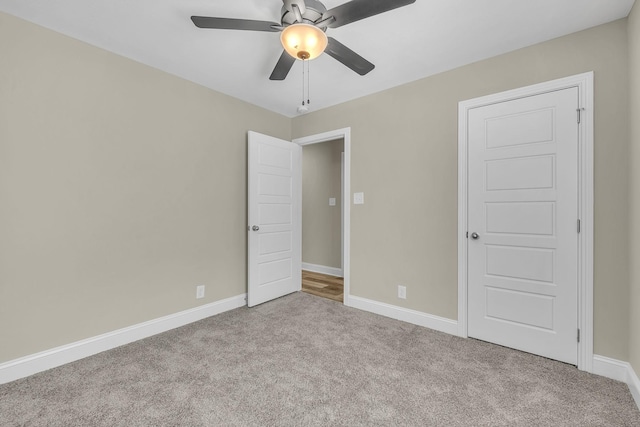 carpeted spare room with ceiling fan