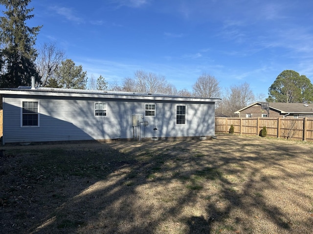 rear view of house featuring a yard