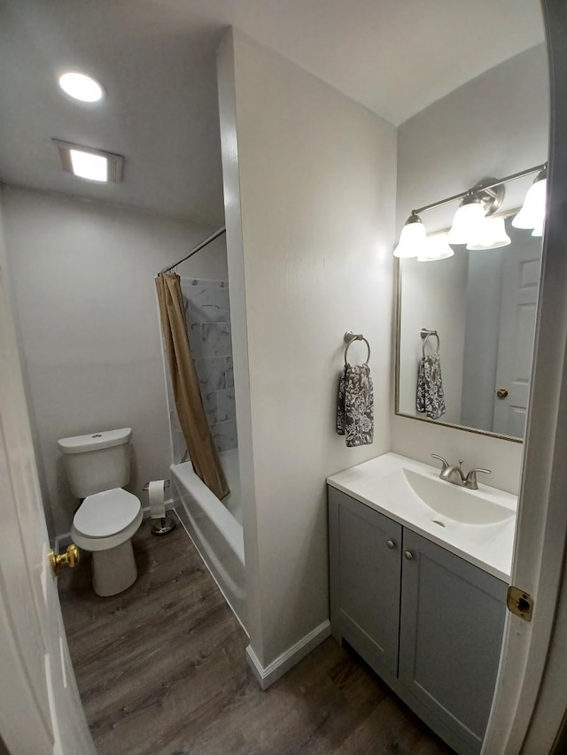 full bathroom featuring vanity, shower / tub combo, hardwood / wood-style flooring, and toilet