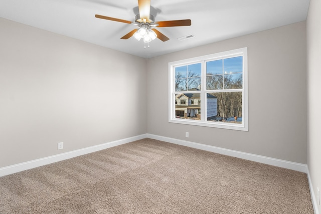 carpeted spare room with ceiling fan