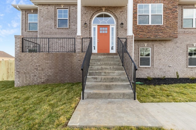 view of exterior entry with a yard