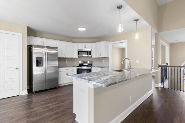 kitchen featuring white cabinetry, light stone counters, pendant lighting, and appliances with stainless steel finishes