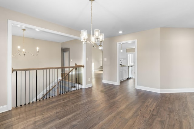 spare room with sink, dark hardwood / wood-style floors, and a chandelier