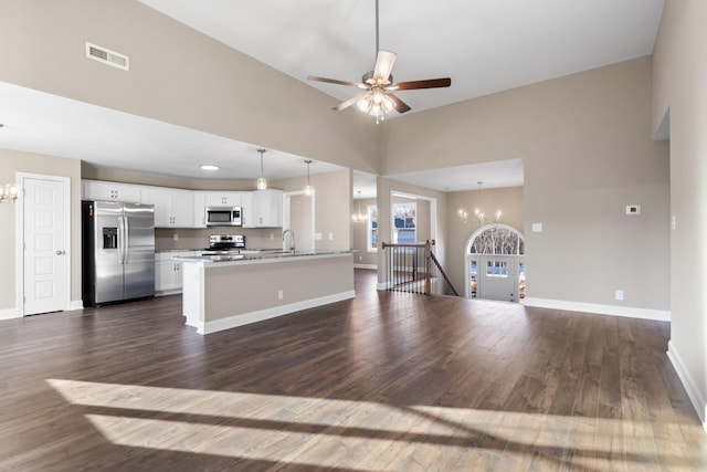 kitchen with appliances with stainless steel finishes, pendant lighting, white cabinetry, sink, and dark hardwood / wood-style flooring