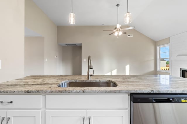 kitchen featuring light stone countertops, stainless steel dishwasher, sink, and white cabinets