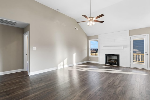 unfurnished living room featuring ceiling fan, a large fireplace, lofted ceiling, and dark hardwood / wood-style flooring