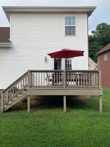 rear view of house with a deck and a lawn