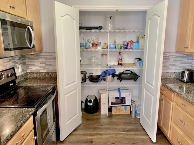 kitchen with appliances with stainless steel finishes, dark hardwood / wood-style floors, and light brown cabinetry