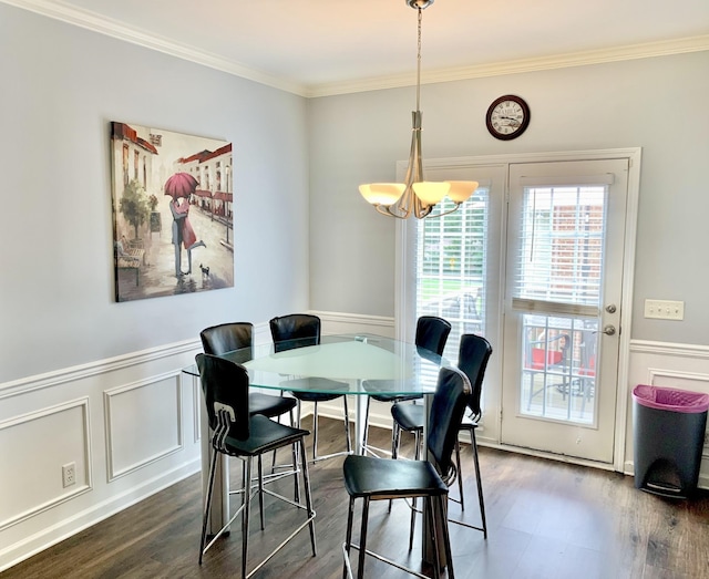 dining area with dark hardwood / wood-style flooring, crown molding, and a chandelier