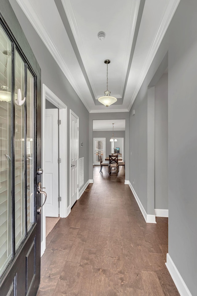 foyer entrance featuring crown molding and a raised ceiling