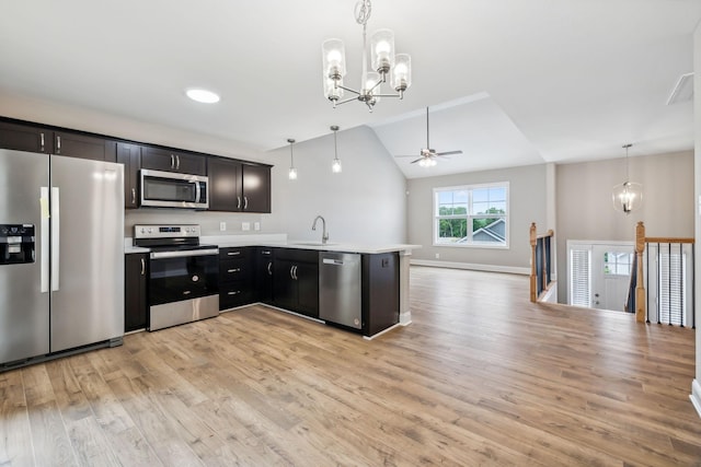 kitchen with sink, light wood-type flooring, kitchen peninsula, pendant lighting, and stainless steel appliances