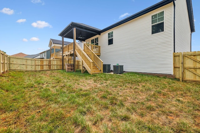 back of house featuring a yard, a deck, ceiling fan, and central air condition unit