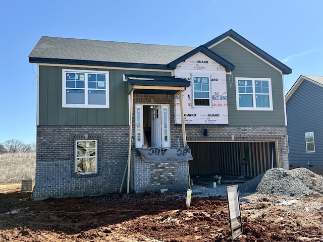 view of front of home with board and batten siding, brick siding, and an attached garage