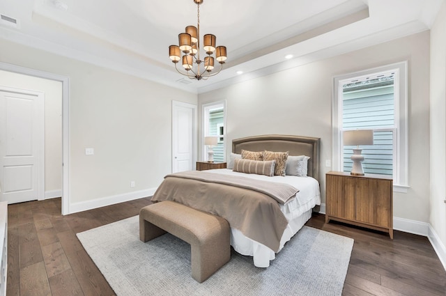 bedroom featuring an inviting chandelier, crown molding, dark wood-type flooring, and a raised ceiling