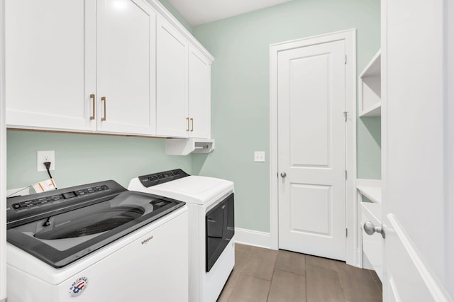 clothes washing area featuring cabinets and independent washer and dryer