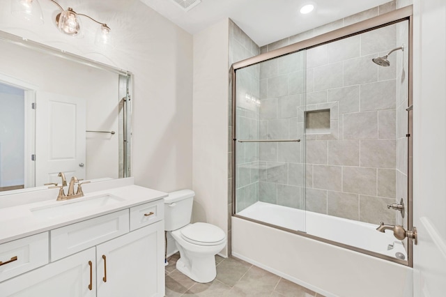 full bathroom featuring vanity, tile patterned floors, shower / bath combination with glass door, and toilet