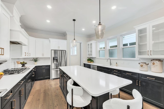 kitchen with pendant lighting, a breakfast bar area, stainless steel appliances, a kitchen island, and decorative backsplash