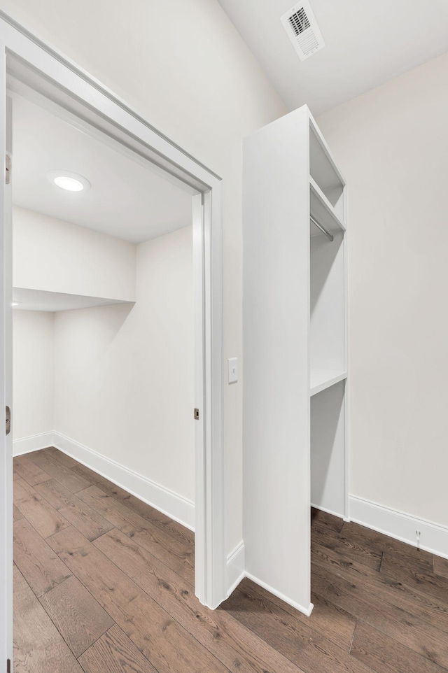 walk in closet with dark hardwood / wood-style floors