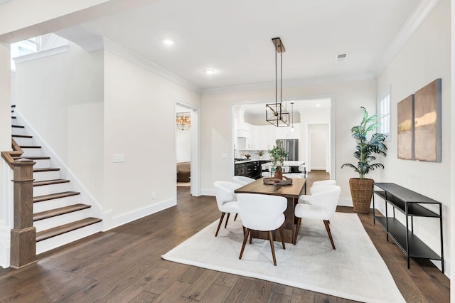 dining space with ornamental molding, dark hardwood / wood-style flooring, and a chandelier