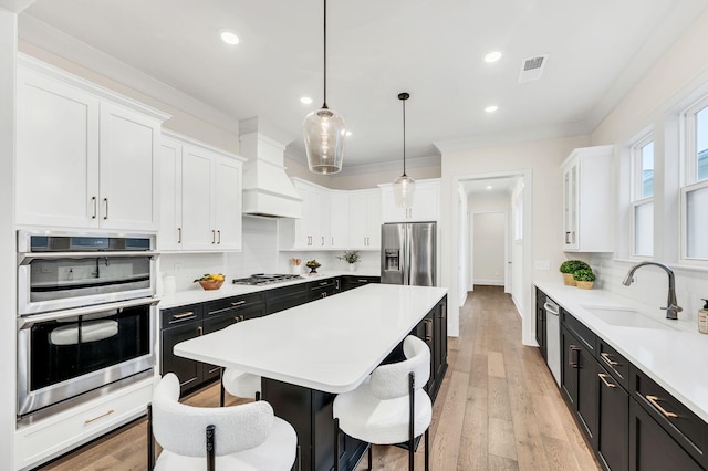 kitchen with tasteful backsplash, pendant lighting, white cabinets, and stainless steel appliances